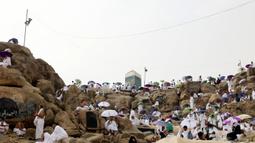 Jemaah haji berkumpul di sekitar Jabal al-Rahma (Gunung Rahmat) saat menunaikan prosesi wukuf di Padang Arafah, tenggara Kota Suci Mekah, Arab Saudi, Senin (19/7/2021). Wukuf di Padang Arafah dua tahun terakhir berada dalam pembatasan karena pandemi corona virus COVID-19. (FAYEZ NURELDINE/AFP)