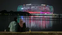 Sepasang kekasih tengah menikmati Jakarta International Stadium (JIS) yang dilihat dari Danau Cincin, Papango, Tanjung Priok, Jakarta Utara, 19 April 2022. (Bola.com/Bagaskara Lazuardi)