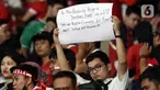 Suporter timnas Indonesia membentang tulisan berisi pesan usai menyaksikan laga timnas Indonesia melawan Thailand pada lanjutan kualifikasi Grup A Piala AFF 2022 di Stadion Utama Gelora Bung Karno, Jakarta, Kamis (29/12/2022). Laga berakhir imbang 1-1 meski Indonesia sempat unggul lewat gol yang dicetak Marc Anthony Klok lewat titik putih. (Liputan6.com/Helmi Fithriansyah)