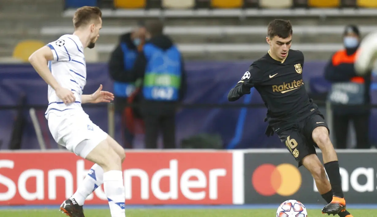 Pemain Barcelona Pedri (kanan) mengontrol bola melewati pemain Dynamo Kyiv Tomasz Kedziora pada pertandingan Grup G Liga Champions di Stadion Olimpiyskiy, Kyiv, Ukraina, Selasa (24/11/2020). Barcelona membantai Dynamo Kyiv 4-0. (AP Photo/Efrem Lukatsky)