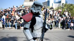 Seorang penggemar cerita dan film Star Wars mengenakan kostum saat parade yang disebut "Hari Pelatihan" di Paseo de la Reforma, Meksiko, pada Sabtu 15 Oktober 2022. Beragam kostum bertema Star Wars dikenakan para penggemar dalam parade tersebut. (ALFREDO ESTRELLA/AFP)