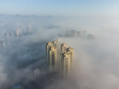 Foto udara ini menunjukkan bangunan yang diselimuti kabut pagi di Bijie, provinsi Guizhou barat daya China (18/11/2021). Bijie  adalah sebuah kota tingkat prefektur di barat laut Provinsi Guizhou, Tiongkok, berbatasan dengan Sichuan di utara dan Yunnan di barat. (AFP/STR)