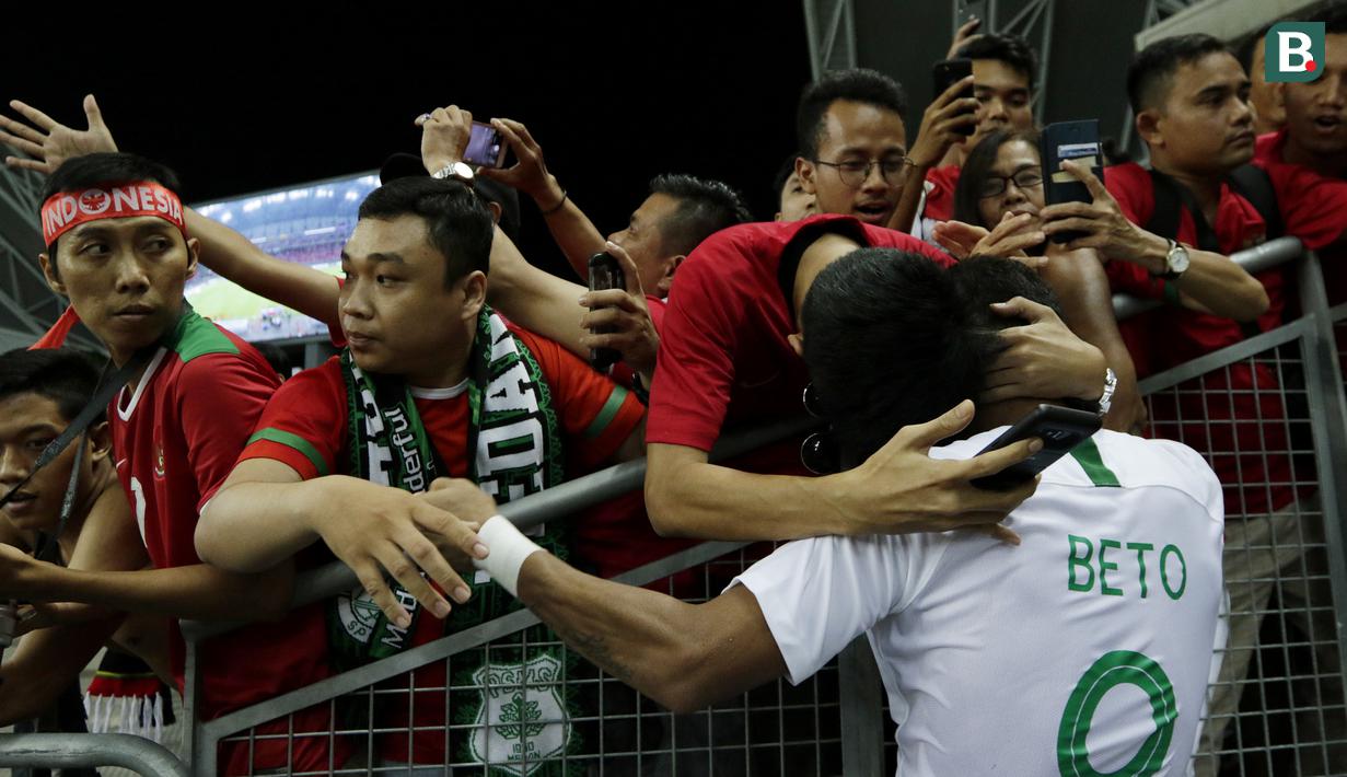 Striker Indonesia, Beto Goncalves, mendapat pelukan dari para suporter  Indonesia meski menelan kekalahan dari Singapura pada laga Piala AFF 2018. (Bola.com/M Iqbal Ichsan)