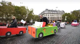 Sejumlah orang naik sepeda yang dihias kardus berbentuk mobil di Place de la Bastille, Paris, Prancis (1/10). Pemerintah Prancis mendorong warganya untuk mengurangi penggunaan kendaraan bermotor guna mengurangi polusi. (AFP Photo/Eric Feferberg)