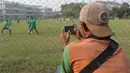 Seorang pekerja merekam sesi latihan Timnas U-19 di Lapangan Legenda Football Arena, Bekasi, Jumat (29/9/2017). Latihan ini untuk persiapan uji coba melawan Kamboja dan Thailand.  (Bola.com/Nicklas Hanoatubun)