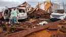 Ren mengambil pakaian dari mobilnya yang rusak akibat badai besar di Negara Bagian Georgia, Amerika Serikat, Minggu (22/1). Setidaknya 18 orang dilaporkan tewas akibat cuaca buruk yang memicu badai tornado. (AP Photo/Branden Camp)