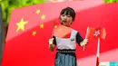 Seorang anak memperkenalkan bendera China dan Hong Kong kepada teman-temannya jelang peringatan penyerahan Hong Kong dari Inggris ke China di taman kanak-kanak di Shenzhen, Guangdong, China, Selasa (30/6/2020). Hong Kong menandai 23 tahun penyerahan dari Inggris ke Cina pada 1 Juli. (STR/AFP)