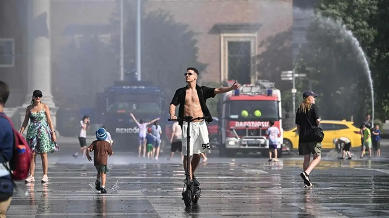 Di tengah gelombang panas ekstrem, polisi mengerahkan meriam air untuk membantu mendinginkan warga di Lapangan Heroes, Budapest, Hungaria.