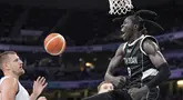 Pebasket Sudan Selatan Wenyen Gabriel (kanan) berselebrasi setelah melakukan dunk saat Nikola Jokic dari Serbia menonton selama pertandingan bola basket putra Olimpiade Paris 2024 di Villeneuve-d'Ascq, Sabtu, 3 Agustus 2024. (AP Photo/Michael Conroy)
