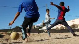 Sejumlah anak Palestina bermain sepak bola di kawasan Gaza, Jumat (3/11/2017). Sepak bola tidak hanya menjadi olahraga favorit, tapi juga sebagai salah satu cara bagi warga untuk mengurangi ketegangan akibat peperangan. (AFP/Mohammed Abed)