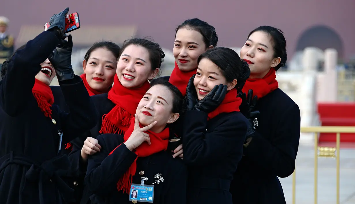 Sejumlah wanita berswafoto saat pembukaan Kongres Rakyat Nasional di Beijing, China, Minggu (3/3). Kongres ini digelar setiap tahun. (AP Photo/Andy Wong)