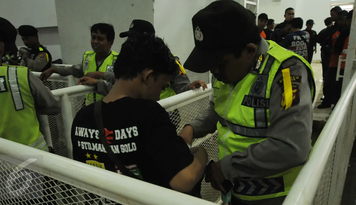 Personel polisi memeriksa suporter yang akan Stadion Pakansari, Kab Bogor, Sabtu (11/3). Jelang laga perebutan tempat ketiga Piala Presiden 2017 antara Semen Padang vs Persib, keamanan Stadion Pakansari diperketat. (Liputan6.com/Helmi Fithriansyah)