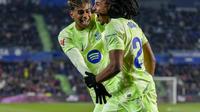 Jules Kounde dari Barcelona, kanan, merayakan golnya bersama Lamine Yamal ke gawang Getafe saat pertandingan sepak bola La Liga Spanyol di stadion Coliseum Alfonso Perez di Getafe, Spanyol, Minggu, 19 Januari 2025. (AP Photo/Manu Fernandez)
