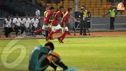 Tiga pemain Timnas Indonesia berlari sambil tersenyum melewati peman Laos yang terduduk lesu usai laskar Merah Putih menambah golnya (Liputan6.com/Helmi Fithriansyah)