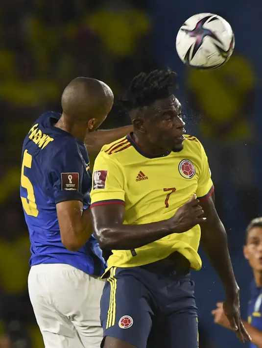 Gelandang Brasil Fabinho (kiri) dan penyerang Kolombia Duvan Zapata berebut bola pada Kualifikasi Piala Dunia 2022 zona Amerika Selatan di Stadion Roberto Melendez, Senin (11/10/2021) dinihari WIB. Brasil ditahan imbang Kolombia 0-0. (JUAN BARRETO / AFP)