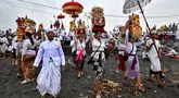 Umat Hindu berjalan untuk berdoa sambil membawa persembahan saat upacara Melasti di sebuah pantai di Denpasar, Bali, pada Rabu 26 Maret 2025. (Sonny TUMBELAKA/AFP)