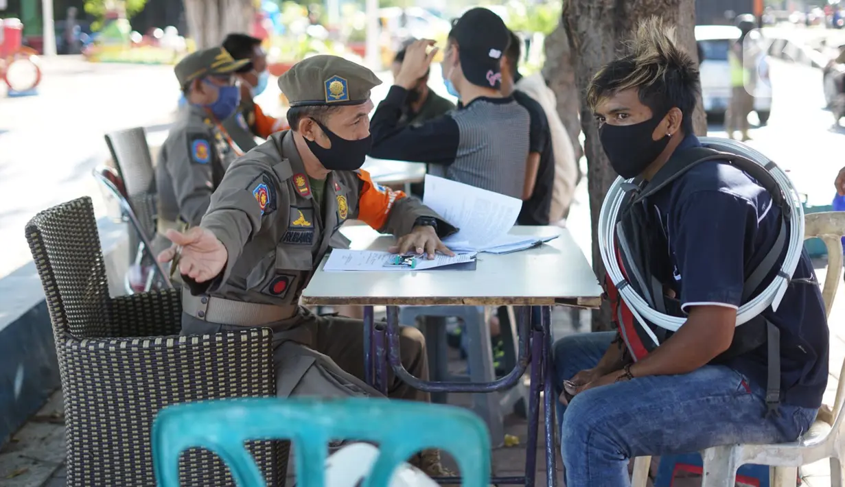 Petugas Satpol PP berbicara dengan warga pelanggar PSBB yang terjaring operasi kepatuhan disiplin masker di kawasan Waduk Sunter, Jakarta, Selasa (8/9/2020). Warga yang kedapatan melanggar akan dikenakan sanksi denda Rp 250 ribu atau membersihkan fasilitas umum. (Liputan6.com/Immanuel Antonius)