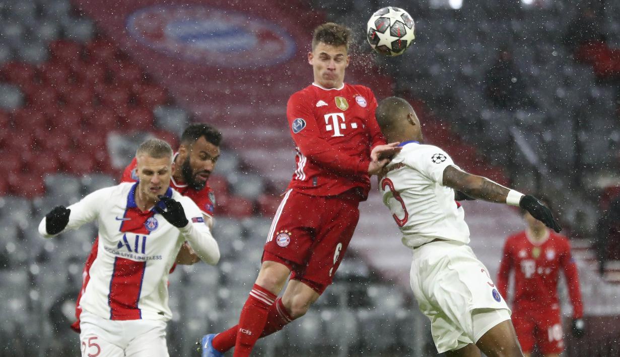 Pemain Bayern Munchen, Joshua Kimmich, duel udara dengan pemain Paris Saint-Germain (PSG), Presnel Kimpembe, pada laga Liga Champions di Allianz Arena, Kamis (8/4/2021). PSG menang dengan skor 3-2. (AP Photo/Matthias Schrader)