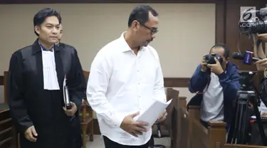 Kepala Kanwil Kemenag Jawa Timur, Haris Hasanuddin yang juga tersangka dugaan pemberian suap kepada anggota DPR Romahurmuziy (tengah) tertunduk usai menjalani sidang pembacaan dakwaan di Pengadilan Tipikor, Jakarta, Rabu (29/5). (Liputan6.com/Helmi Fithriansyah)