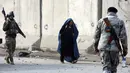 Seorang wanita Afghanistan berjalan di dekat lokasi serangan di Kabul, Afghanistan (15/1). Empat orang tewas dan 113 orang lainnya terluka akibat ledakan yang terjadi di dekat kompleks asing tersebut. (AP Photo/Rahmat Gul)