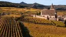 Pemandangan udara gereja Saint-Jacques-le-Majeur yang dikelilingi kebun anggur Alsace pada hari musim gugur di Hunawihr, Prancis timur pada 26 Oktober 2021. Saat memasuki pertengahan bulan Oktober, daun-daun akan berubah warna menyajikan pemandangan musim gugur yang memesona. (SEBASTIEN BOZON / AFP)