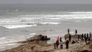 Orang-orang melihat bangkai ikan paus yang terdampar di sebuah pantai kawasan Rosarito, Meksiko, Senin (22/5). Bangkai paus tersebut membuat heboh dan menjadi pusat perhatian bagi pengunjung atau orang yang melintas. (AFP PHOTO/GUILLERMO ARIAS)