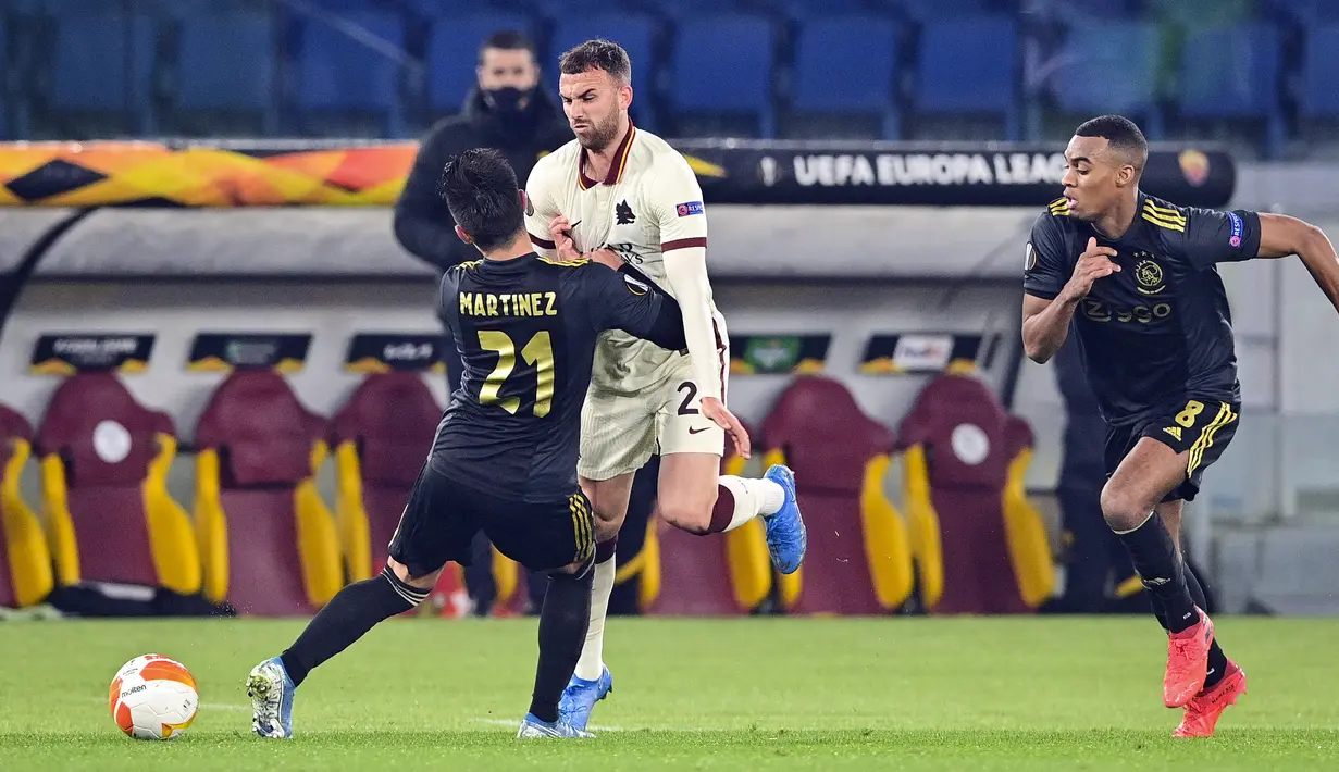 Penyerang AS Roma, Borja Mayoral berebut bola dengan bek Ajax Amsterdam, Lisandro Martinez pada leg kedua perempat final Liga Europa di Olimpico, Jumat (16/4/2021) dini hari WIB. AS Roma melaju ke semifinal Liga Europa musim ini setelah bermain imbang 1-1 lawan Ajax. (Fabio Rossi/LaPresse via AP)