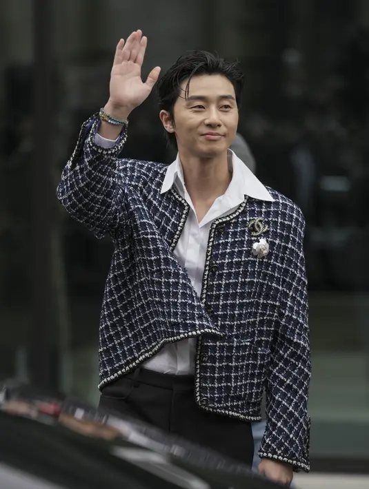 Park Seo-joon menghadiri peragaan busana Chanel untuk koleksi Fall-Winter 2023/24 di Paris Fashion Week, Selasa (7/3/2023). Di dalam, Park Seo-joon mengenakan kemeja putih berkancing sederhana dengan rambut disisir ke belakang sebagai ciri khasnya. (Scott Garfitt/Invision/AP)