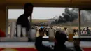 Warga Palestina membakar ban hingga menimbulkan asap tebal di perbatasan Palestina-Israel di kota Gaza tengah (13/4). Mereka melakukan aksi tersebut menyusul tewasnya 33 orang Palestina akibat serangan tentara Israel. (AFP/Mohammed Abed)