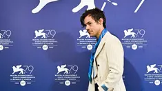 Penyanyi dan aktor Inggris Harry Styles tiba untuk berpose selama sesi pemotretan untuk film "Don't Worry Darling" selama Venice Film Festival 2022 ke-79 di Venesia, Italia (5/9/2022). Harry Styles tampil mengenakan blazer krem bergaris-garis dengan celana panjang hitam longgar dan dasi biru. (AFP/Tiziana Fabi)