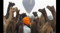 Para wisatawan wanita itu tengah menikmati kunjungan ke Pushkar Camel Fair.