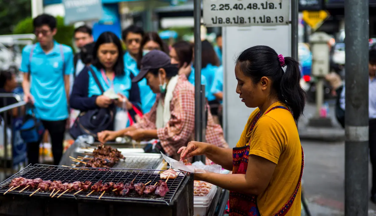Seorang wanita memasak sate di gerobaknya di samping jalan di Bangkok, Thailand (20/9).  Makanan Thailand juga banyak dipengaruhi oleh kultur kuliner Cina, terutama Suku Han. (AFP Photo/Jewel Samad)