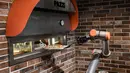 Robot pembuat pizza Bernama "Pazzi" sedang bekerja di sebuah restoran di Paris pada 1 Juli 2021. Pelanggan cukup memesan melalui sebuah terminal atau aplikasi dan memilih pizza yang diinginkan dan menentukan waktu pengambilan. (BERTRAND GUAY/AFP)