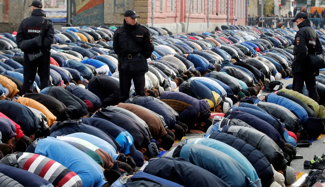 Sejumlah petugas berjaga saat warga Muslim Rusia melaksanakan Salat Idul Adha di dekat Masjid Agung Moskow, Rusia, Senin (12/9). (REUTERS / Maxim Zmeyev)