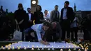 Warga menulis ucapan duka di spanduk putih untuk mengenang kematian tragis anggota parlemen Inggris, Jo Cox (41) di alun-alun parlemen, London, Kamis (16/6). Jo Cox diserang ketika hendak menemui konstituennya di Birstall. (Daniel Leal-Olivas/AFP)
