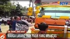 Pelarangan truk pasir yang melintas di permukiman warga dilakukan dengan menutup jalan dengan batu dan kayu.