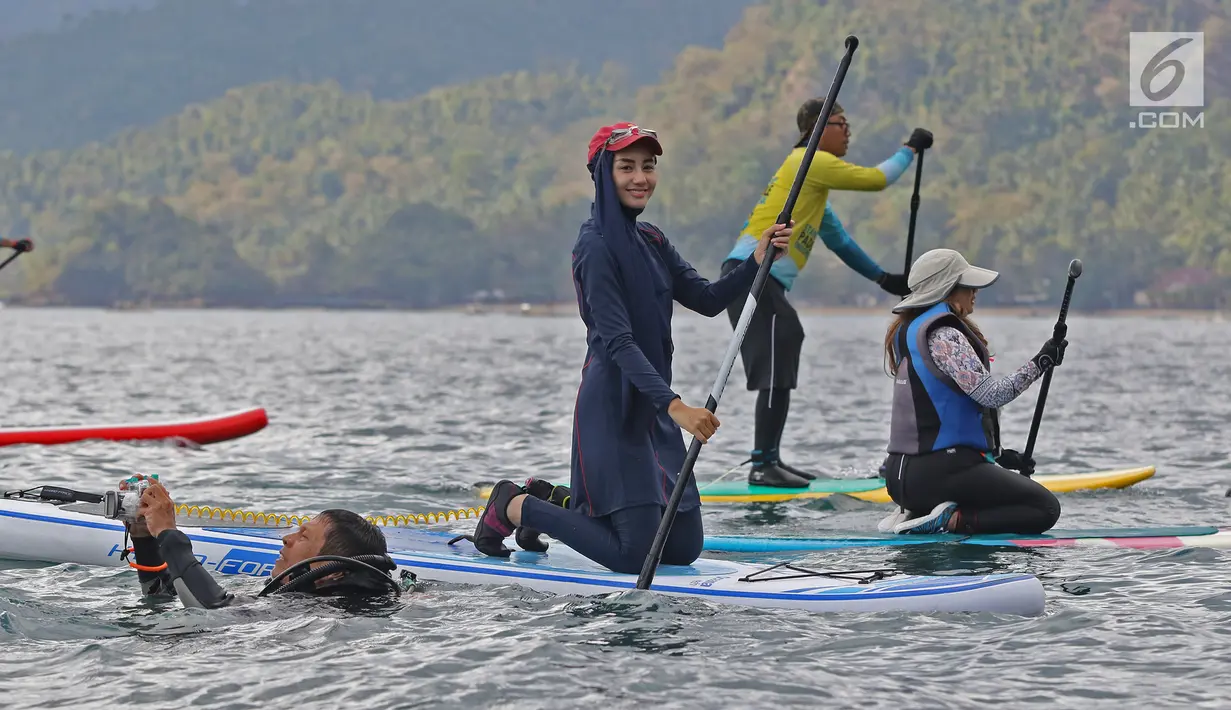 Istri bupati Trenggalek Mochammad Nur Arifin, Novita Hardini tersenyum saat olah raga Stand Up Paddle di Pantai Mutiara, Trenggalek, Jawa Timur, Sabtu (7/9/2019). Bermain Stand Up Paddle merupakan salah satu olah raga air atau wisata. (Liputan6.com/Herman Zakharia)