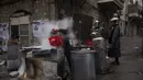 Seorang pria Yahudi ultra-Ortodoks mencelupkan peralatan masak ke dalam air mendidih untuk menghilangkan sisa-sisa ragi sebagai persiapan untuk hari raya Paskah Yahudi di Yerusalem (26/3/2021).  (AP Photo/Oded Balilty)