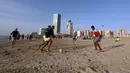 Orang-orang bermain bola di pantai sembari menunggu waktu berbuka puasa selama bulan suci Ramadan, meskipun lockdown karena pandemi COVID-19, di ibu kota Tripoli, Libya pada Jumat (8/5/2020). (Photo by Mahmud TURKIA / AFP)