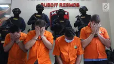 Empat WNA tersangka menutupi wajah saat pengungkapan tiga kasus pencurian data elektronik (Skimming) di Polda Metro Jaya, Jakarta, Selasa (4/3). Empat tersangka tersebut berhasil diamankan Ditreskrimum Polda Metro Jaya. (Liputan6.com/Arya Manggala)