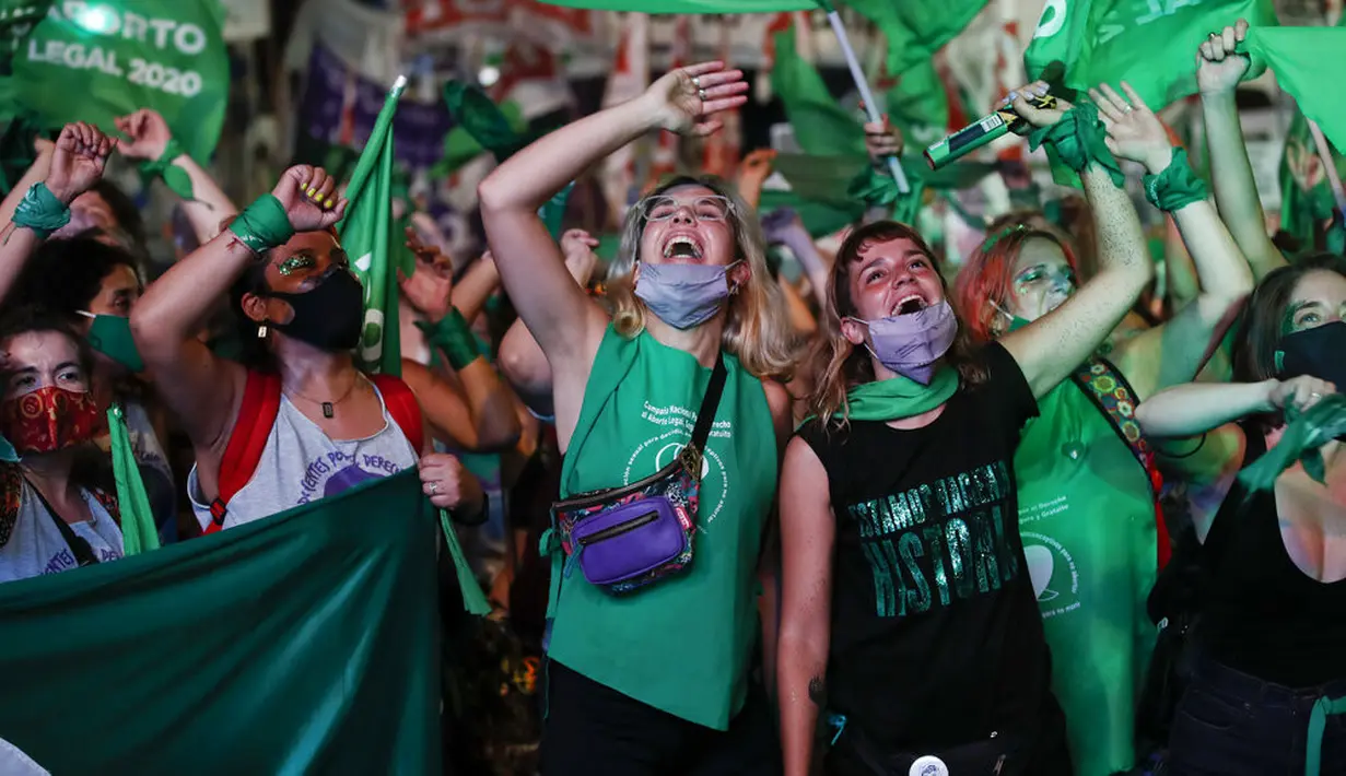 Aktivis hak-hak aborsi menonton siaran langsung sidang parlemen di luar Kongres, Buenos Aires, Argentina, Rabu (30/12/2020). Kongres Argentina menyetujui undang-undang yang melegalkan aborsi. (AP Photo/Natacha Pisarenko)