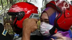 Penumpang sepeda motor menjalani pengecekan suhu tubuh saat akan masuk Kompleks Parlemen di Senayan, Jakarta, Kamis (5/3/2020). Pengecekan dilakukan sebagai tindakan preventif terkait penyebaran virus corona (COVID-19) setelah dua WNI dinyatakan positif terinfeksi. (Liputan6.com/Johan Tallo)