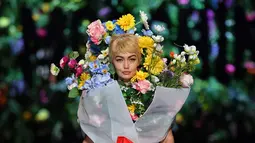 Top model Gigi Hadid mengenakan rancangan rumah mode Moschino saat Milan Fashion Week di Italia, Kamis (21/9). Dalam catwalknya Gigi Hadid mengenakan atribut penuh bunga di tubuhnya. (AFP Photo/Marco Bertorello)