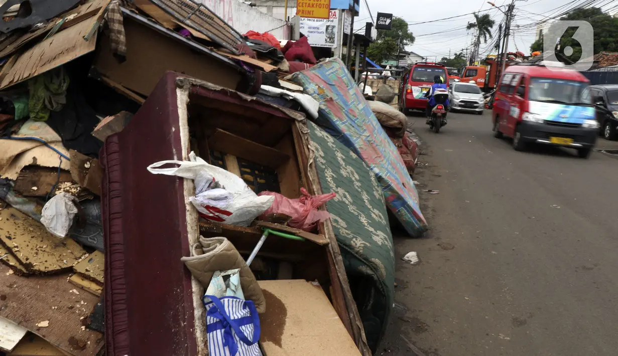 Tumpukan sampah terlihat menumpuk di sepanjang jalan pascabanjir mulai surut di kawasan Kembangan, Jakarta Barat, Minggu (5/1/2020). Nantinya sampah-sampah ini akan diangkut oleh petugas kebersihan menggunakan truk pengangkut sampah yang akan dibawa ke TPA Bantar Gebang.  (Liputan6.com/Johan Tallo)
