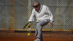 Artyn Elmayan, seorang pria asal Armenia, bermain tenis di River Plate Club di Buenos Aires, Selasa (16/5). Meski usianya telah mencapai 100 tahun, Artyn mengaku tetap rutin main tenis tiga kali seminggu. (AFP FOTO / Eitan ABRAMOVICH)