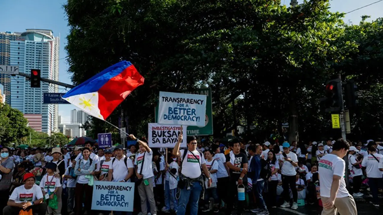Anggota kelompok keagamaan Iglesia Ni Cristo (Church of Christ) mengangkat poster selama aksi unjuk rasa antikorupsi di Taman Rizal, Manila, Filipina, pada Minggu (16/11/2025).