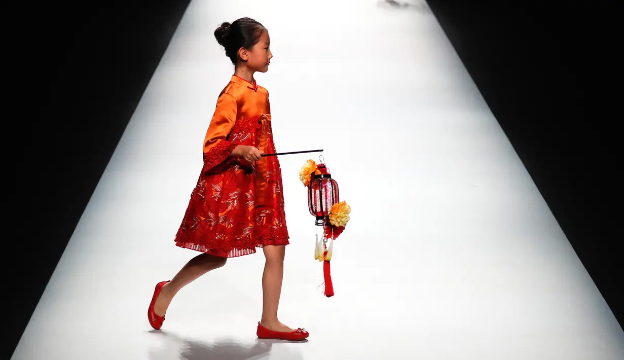 Seorang anak berjalan di atas catwalk membawakan karya desainer Amelie Wang pada China Fashion Week di Beijing,  31 Oktober 2017. (AP Photo/Andy Wong)