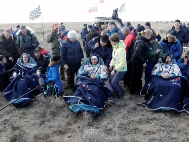 Astronot AS Kate Rubins, kosmonot Rusia Anatoly Ivanishin, dan astronot Jepang Takuya Onishi beristirahat setelah berhasil mendarat di daerah terpencil sekitar 150 km sebelah tenggara dari Dzhezkazgan, Kazakhstan (30/10). (Reuters/Dmitri Lovetsky)