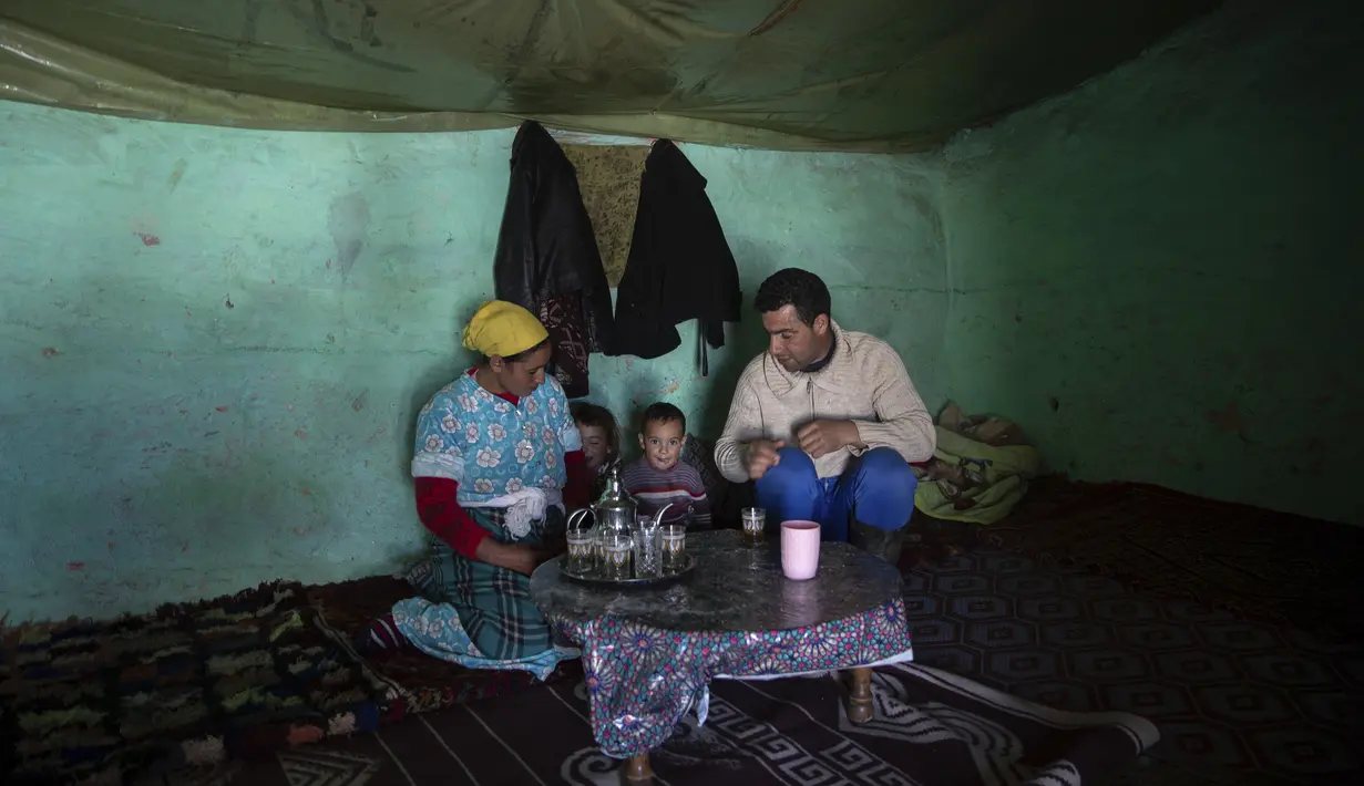 Muhammad Miloud minum teh bersama istri dan anak-anaknya, Houda dan ihsan, di desa Amazigh Timahdite di Atlas Tengah, dekat Azrou, Maroko (4/12/2021). Desa ini berada di ketinggian 1.800 meter (5.900 kaki) di Pegunungan Atlas Tengah. (AP Photo/Mosa'ab Elshamy)