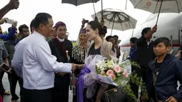 Utusan khusus UNHCR, Angelina Jolie berjabat tangan dengan Menteri Negara bagian Kachin, La John Ngan Hsai saat tiba di Bandara Myitkyinam, Myanmar, Rabu (30/7/2015). (REUTERS/Soe Zeya Tun)
